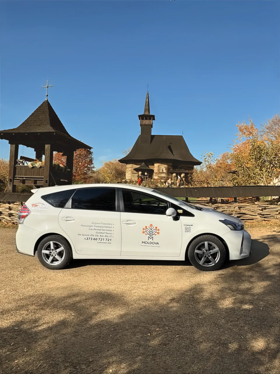 Prius+ an einer Holzkapelle